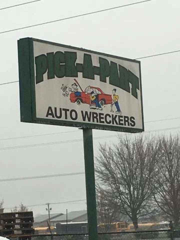 Pick-A-Part Auto Wreckers sign with cartoon graphics.