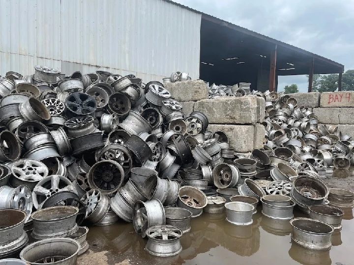 Piled aluminum wheels at a recycling facility.