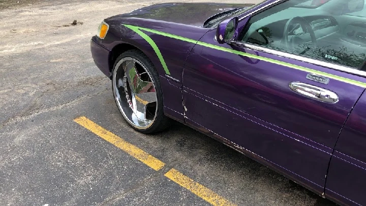 Purple car with green accents and large rims.