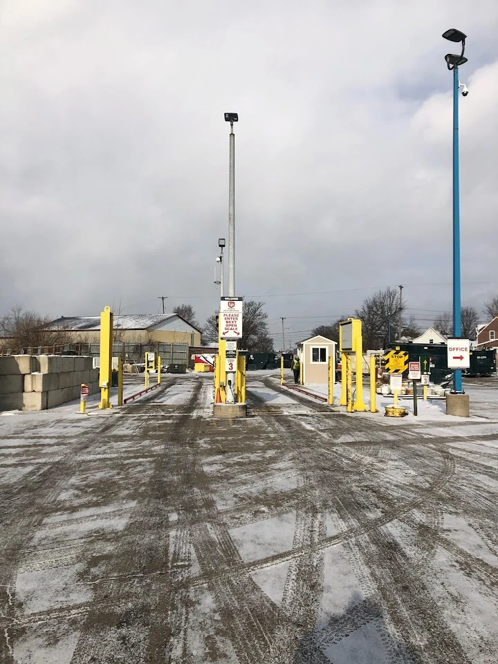 Recycling center entrance with signage and equipment.