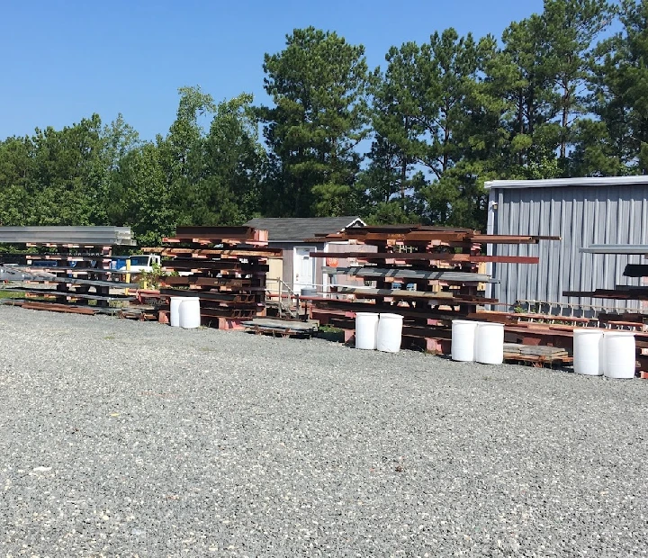 Recycling yard with stacked metal and containers.