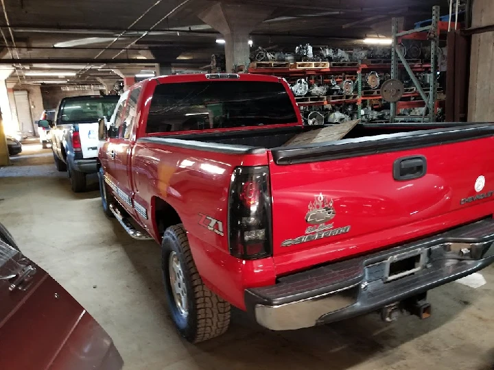 Red Chevrolet Silverado in an auto parts garage.