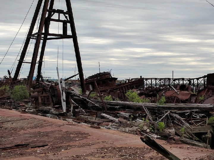 Rusting machinery and debris at a recycling site.