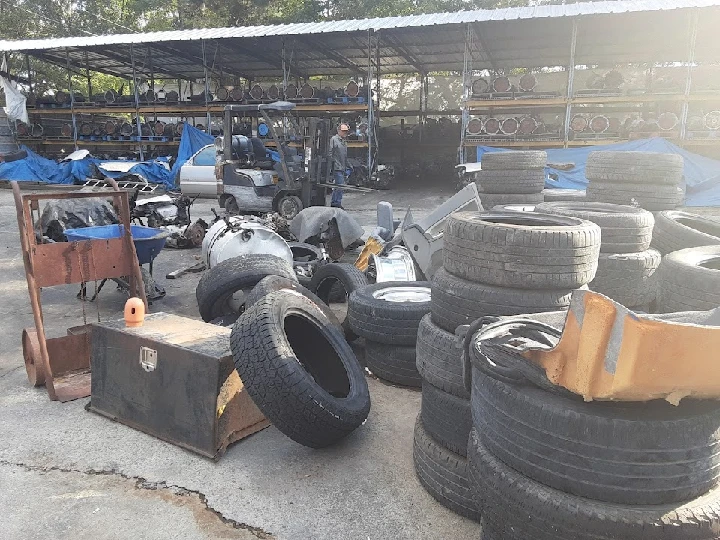 Salvage yard with piles of tires and scrap materials.