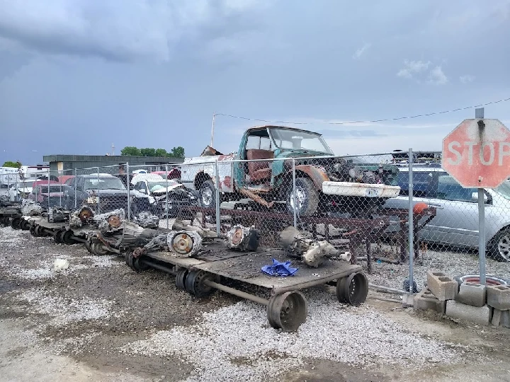 Salvage yard with vehicles and auto parts.