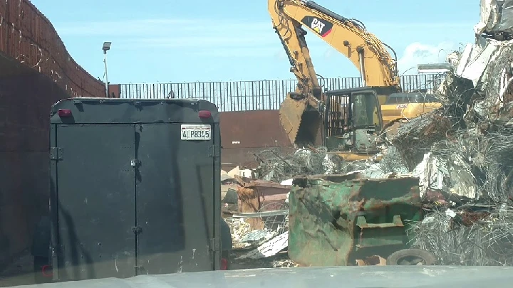 Scrap metal recycling yard with heavy machinery.