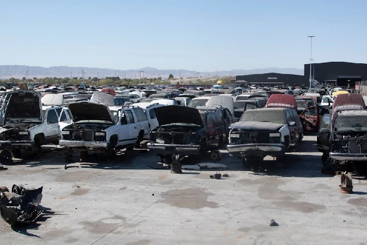 Scrapyard with numerous dismantled vehicles.