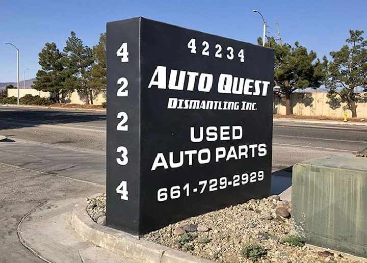 Sign for Auto Quest Dismantling, Inc. with contact info.