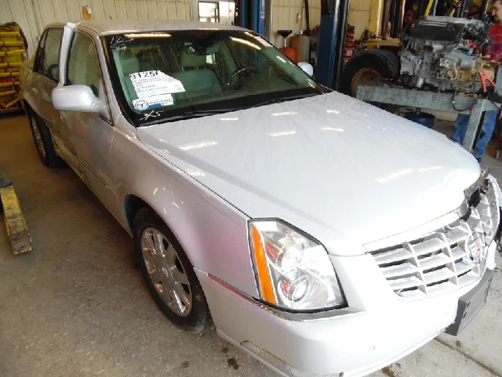 Silver sedan in an auto parts shop garage.