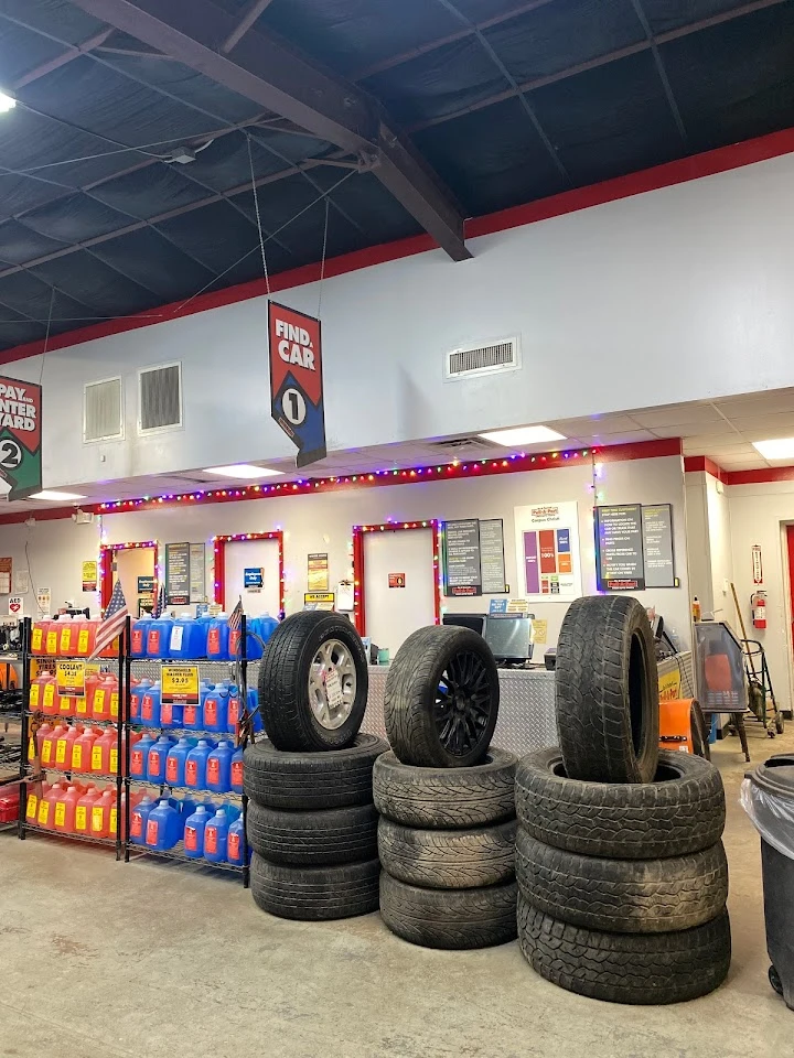 Tires stacked in an auto parts store interior.