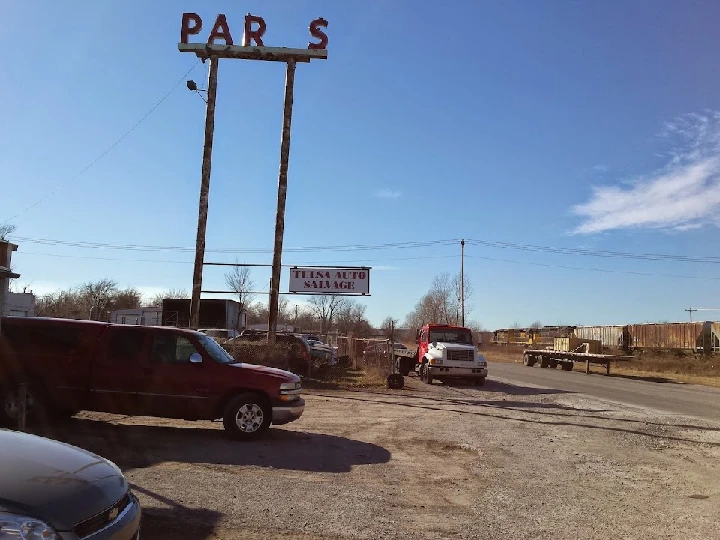 Tulsa Auto Salvage sign and parked vehicles.