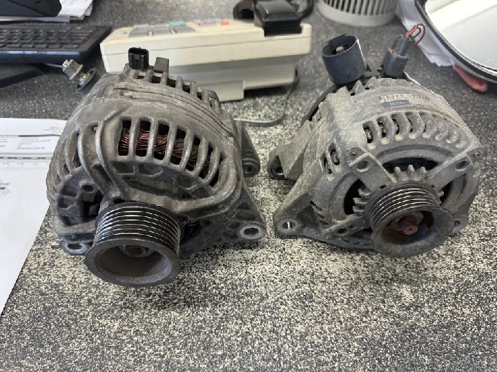 Two alternators on a workbench at Four Lane Auto Parts.