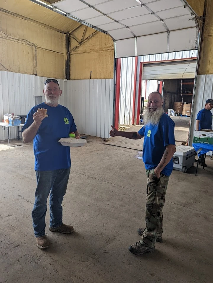 Two men enjoying food at Frailey's Recycling.