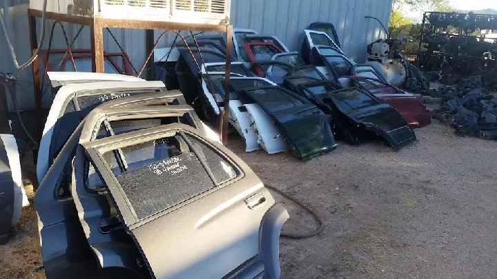 Used vehicle doors stacked at Ace Pickup Parts.