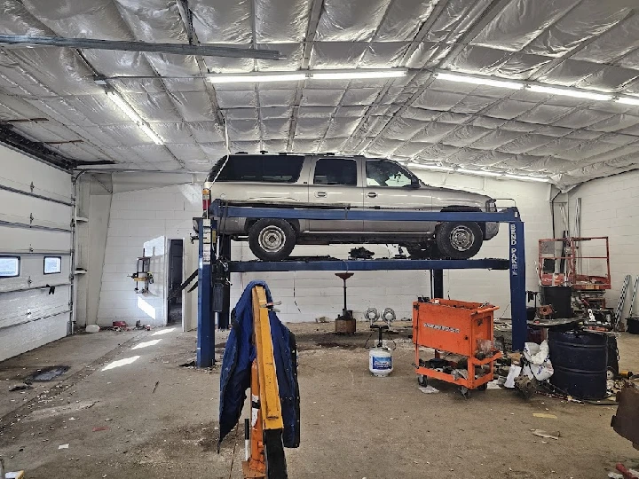 Vehicle on a lift inside an auto parts facility.