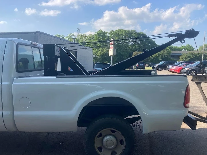 White pickup truck with a tow crane attachment.