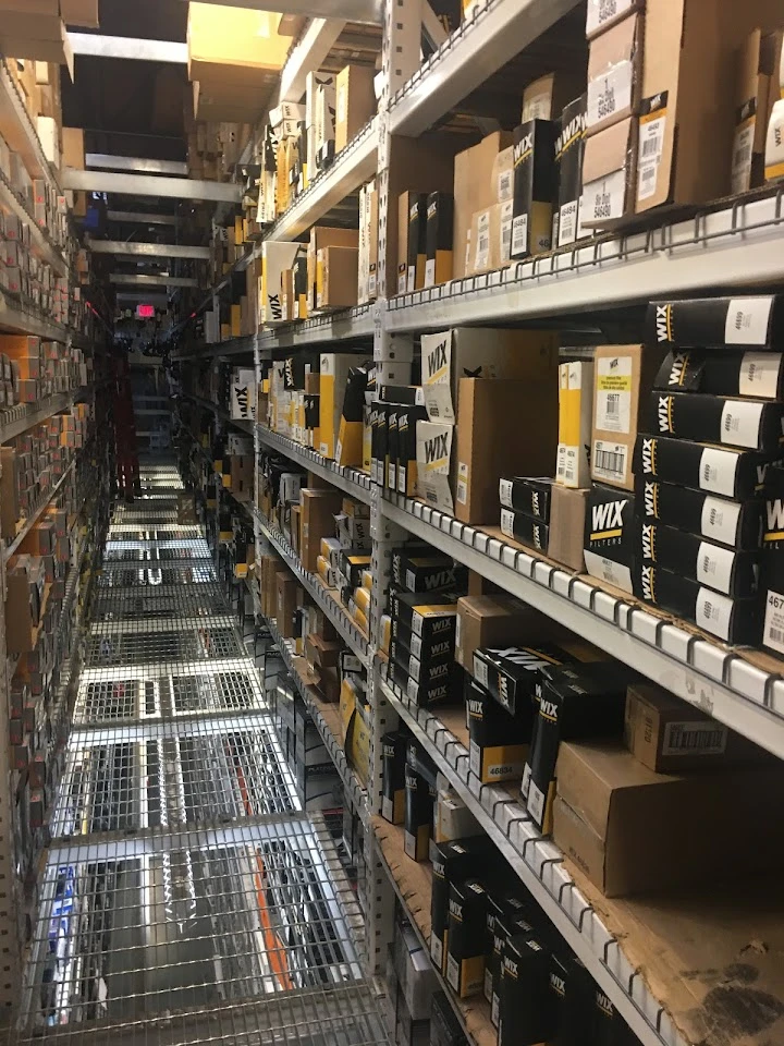 Aisle filled with auto parts boxes.