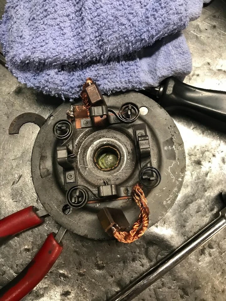 Alternator starter parts on a work surface.