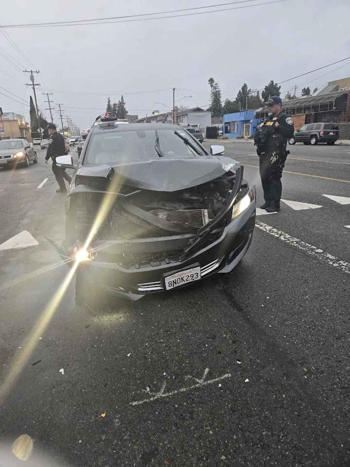 Car accident with a damaged front, police present.