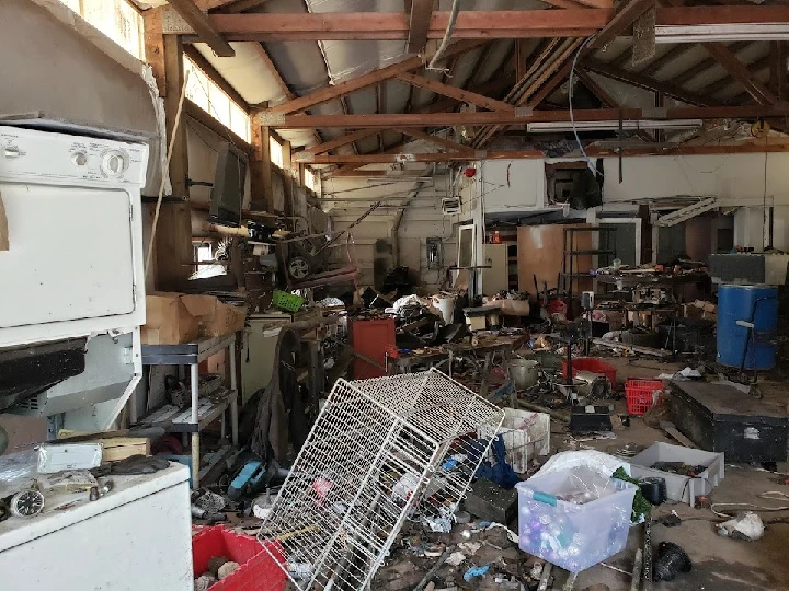 Cluttered recycling space filled with various items.