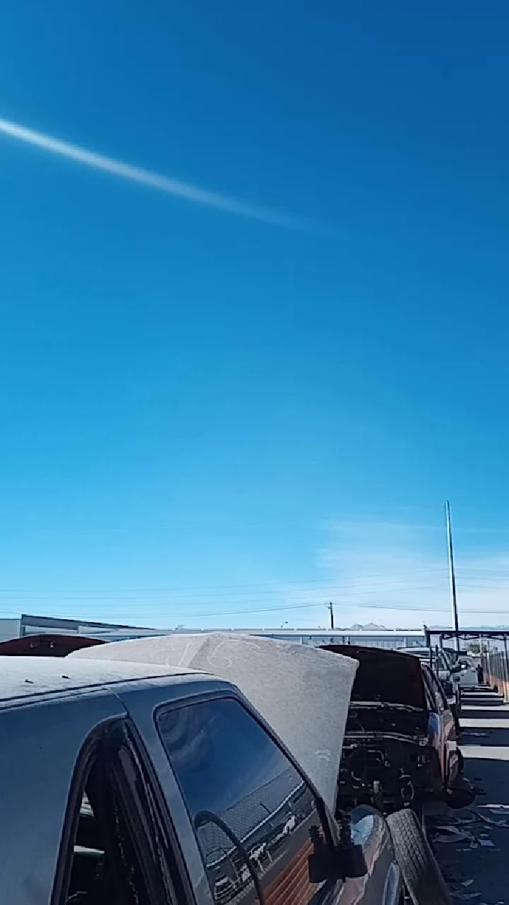 Abandoned cars under a clear blue sky.