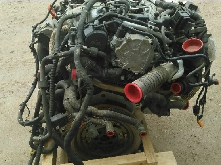 Auto engine with wiring harness and hoses on wood.