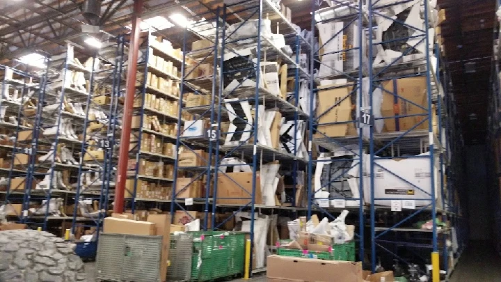 Warehouse shelves stacked with auto parts and boxes.